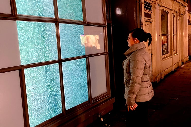A passerby enjoys the digital art on High Street, Brecon.