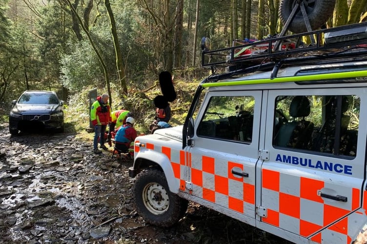 Mountain rescuers assisting the young lady at the waterfall