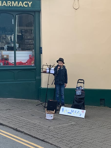 George busking to raise money for refugees