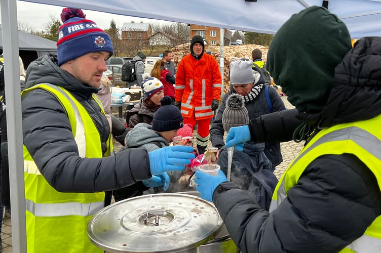 Serving a hot chicken and potato dish to refugees