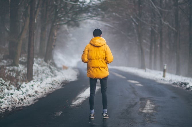 Man in a winter coat on a road in winter