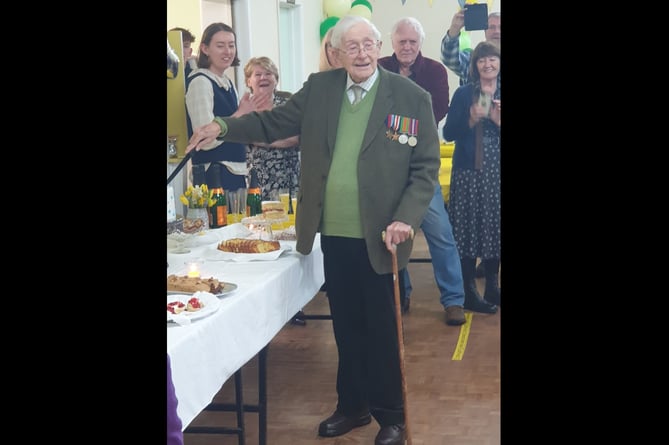 John Gwynne cuts his 101st birthday cake, surrounded by family and friends 