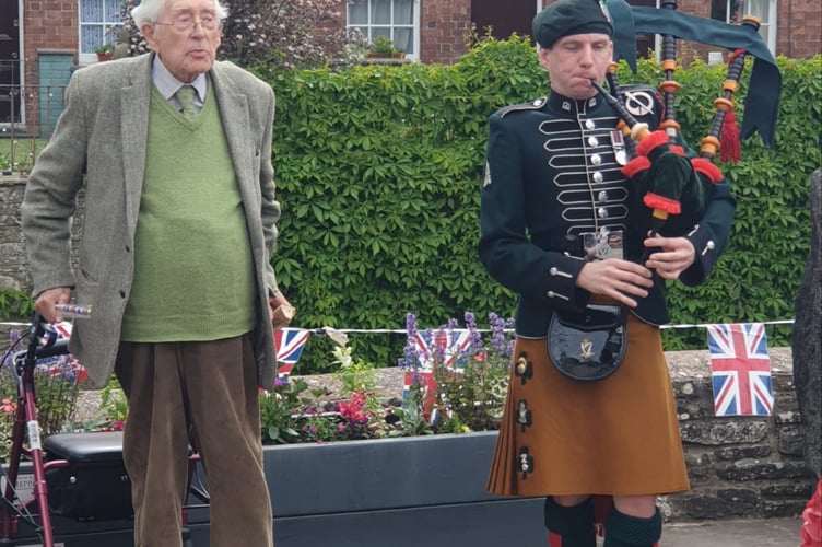 Talgarth's senior resident John Hugo Gwynne, 101, greets Kris the Piper on the bank of the Enig