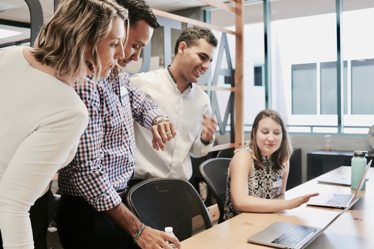 A group of people around a laptop