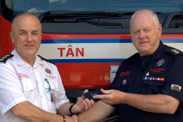 Bryan Davies receiving a long service award from station manager Simon Prince
