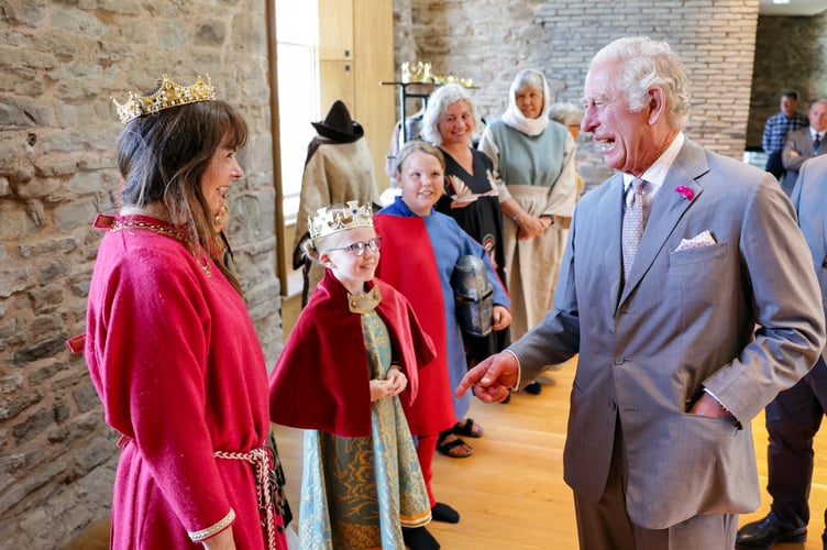 The Prince of Wales with people dressed up as former residents of the castle during his visit to Hay Castle in Hay-on-Wye, Powys, Wales. Picture date: Thursday July 7, 2022.