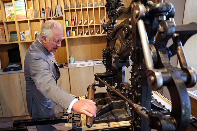 The Prince of Wales creates a lino print on an 1800's printing press during his visit to Hay Castle in Hay-on-Wye, Powys, Wales. Picture date: Thursday July 7, 2022.