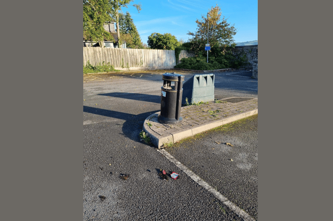 A bottle lies smashed next to an overflowing bin in Presteigne