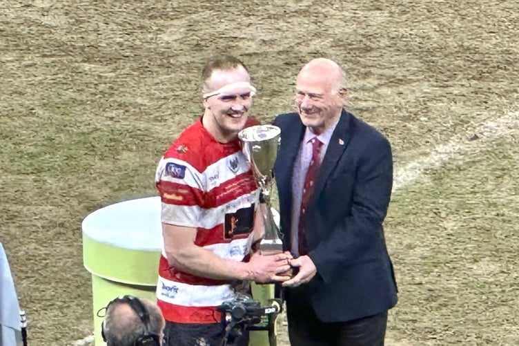 Llandovery skipper Jack Jones receives the Premiership Cup from WRU President Terry Cobner