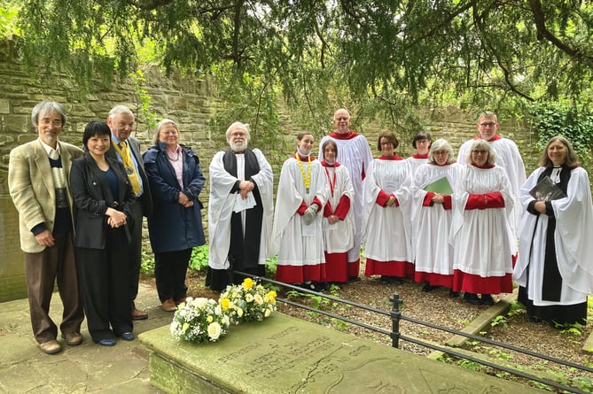 The wreath-laying group at the grave of Henry Vaughan in Llansantffraed churchyard.  The Japanese visitors are on the left, and the speaker Prof Alison Milbank is on the right.