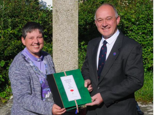 Rev Rachael Storer receiving the Binder from Mr Phillip Jones