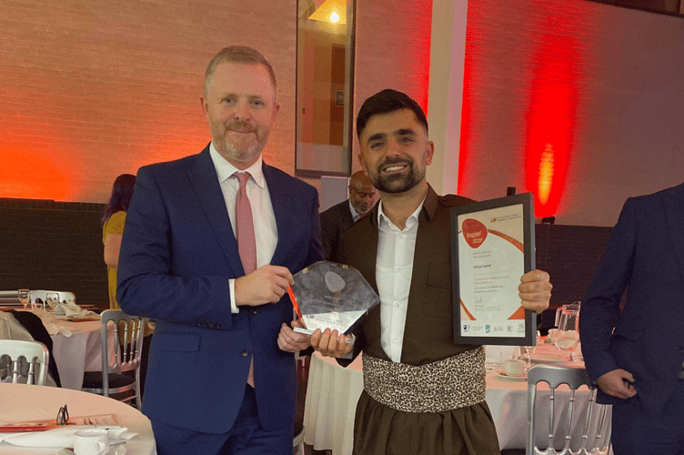 Hawkar with Jeremy Miles, then Cabinet Secretary for Education, receiving the Inspirational Student of the Year award in Wales