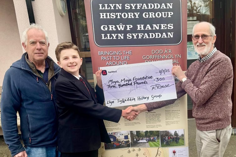 Roger Reese of Llyn Syfaddan History Group presents a £300 cheque to Ryley Reed in support of the MoyaMoya Foundation.