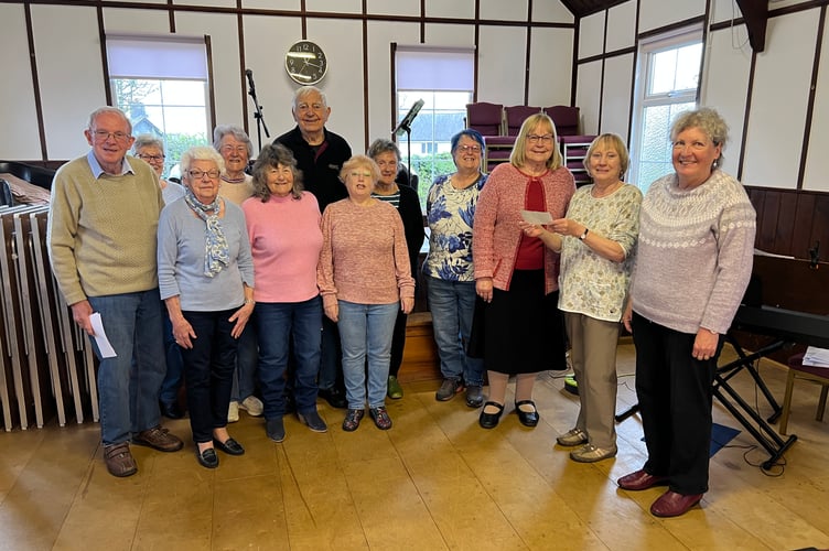 Vera Buckler, leader of the Bracken Trust Singers, accepts a £463 donation from Cynthia Shepperd, Chair of the Powys WI Committee, during a presentation at Llanyre Church Hall on April 15
