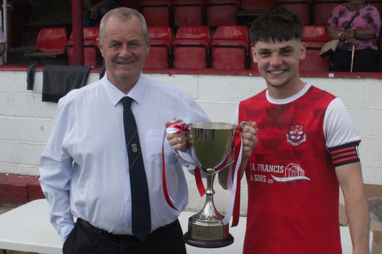 Radnor Robins captain Jack Francis accepts the trophy from Paul Worts