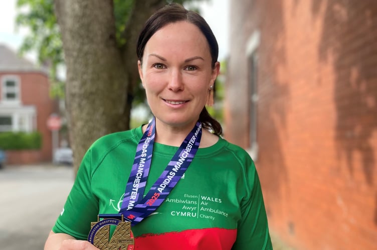 Kelly Edwards celebrates after completing the Manchester Marathon in aid of the Wales Air Ambulance