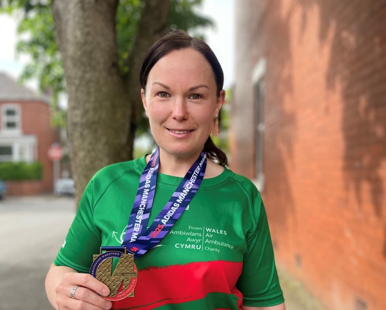 Kelly Edwards celebrates after completing the Manchester Marathon in aid of the Wales Air Ambulance