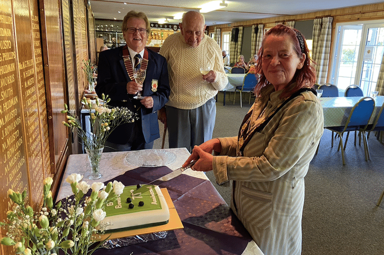 Brecon Mayor Marie Matthews cutting the celebratory cake, marking 75 years of Brecon Bowls Club.