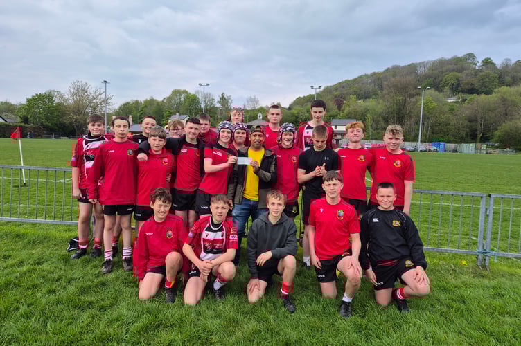 Ash, owner of Brecon Tandoori, presents a £500 cheque to Brecon RFC under-14s