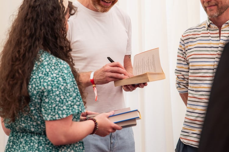 Author Matt Haig signs books for festival goers at the 2025 Hay Festival. Credit: Sam Hardwick and Hay Festival.
