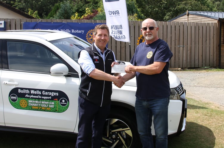 Builth Wells Past Rotary President, John Price receiving a cheque from Tim Evans of Builth Wells Garages, on behalf of himself and brother Martyn