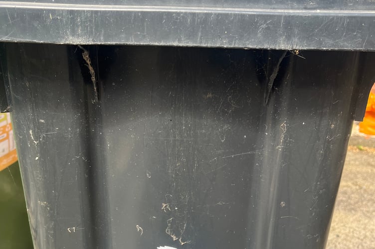 A black waste bin