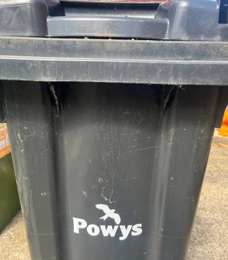 A black waste bin