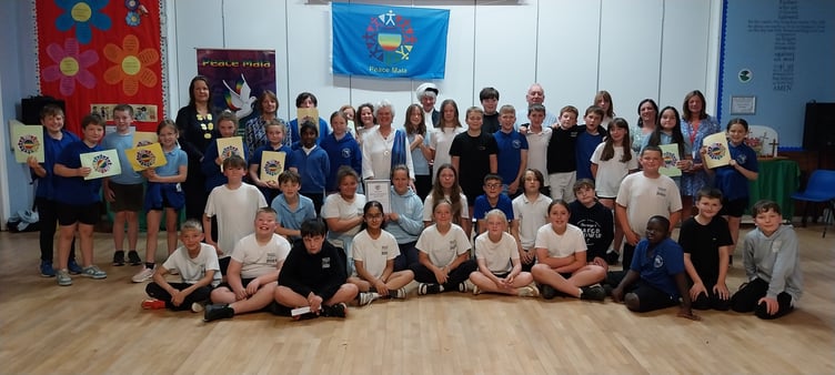 Pupils and staff from Rhayader Church in Wales Primary School celebrate receiving the Peace Mala Platinum Award