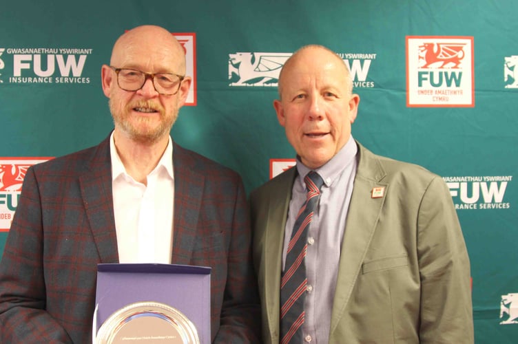 John Owen (left) receiving his award from FUW President Ian Rickman at the Royal Welsh Show