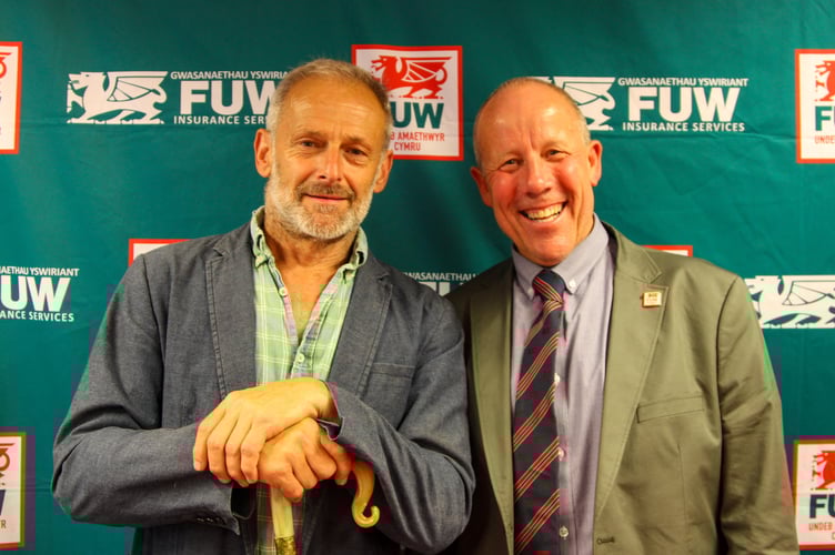 Alun Edwards (left) receiving a shepherds crook from FUW President Ian Rickman at the Royal Welsh Show