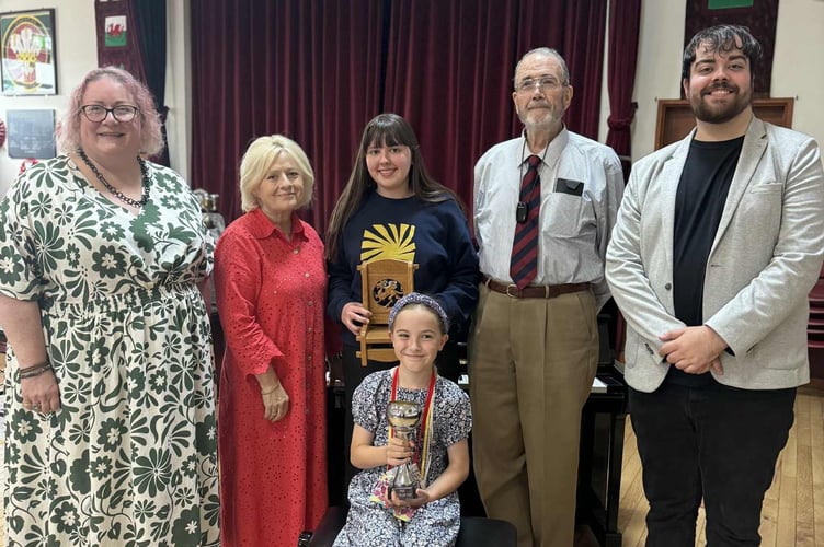 Afternoon President Abigail Hook pictured with adjudicator Meinir Richards, Chair winner Lea Mererid, chair-maker Alec Tompkins, adjudicator Daniel O'Callaghan, and in front, Carys Lewis, winner of the Mrs Mary Price Maesydd Cup