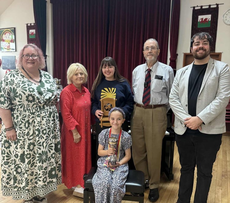 Afternoon President Abigail Hook pictured with adjudicator Meinir Richards, Chair winner Lea Mererid, chair-maker Alec Tompkins, adjudicator Daniel O'Callaghan, and in front, Carys Lewis, winner of the Mrs Mary Price Maesydd Cup