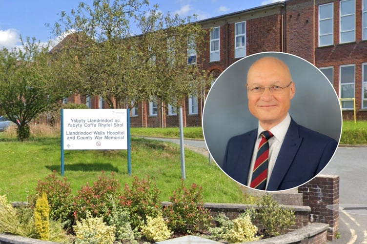 Dr Carl Cooper is Chairman of Powys Teaching Health Board. Behind is Llandrindod Wells War Memorial Hospital