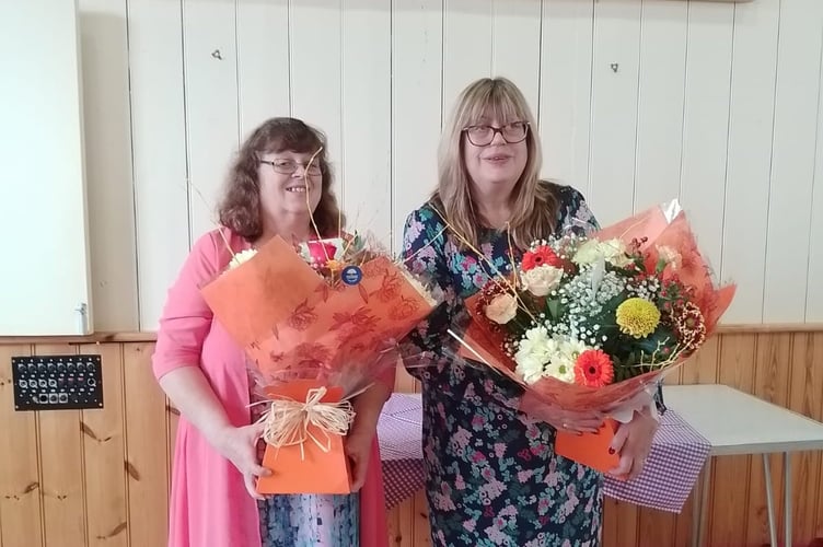 Marian Roff and Jenny Griffiths receiving flowers and gifts in recognition of their years of service at the Llangammarch Post Office and Shop
