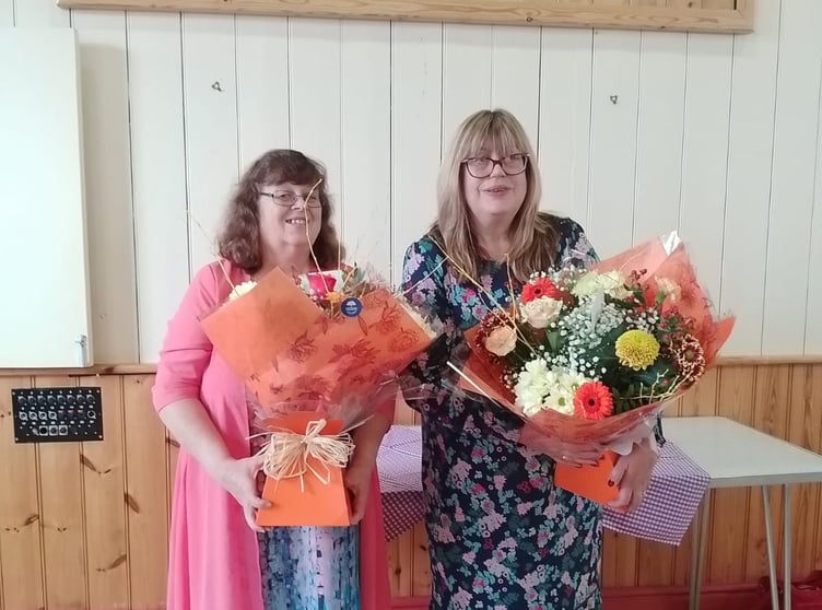 Marian Roff and Jenny Griffiths receiving flowers and gifts in recognition of their years of service at the Llangammarch Post Office and Shop
