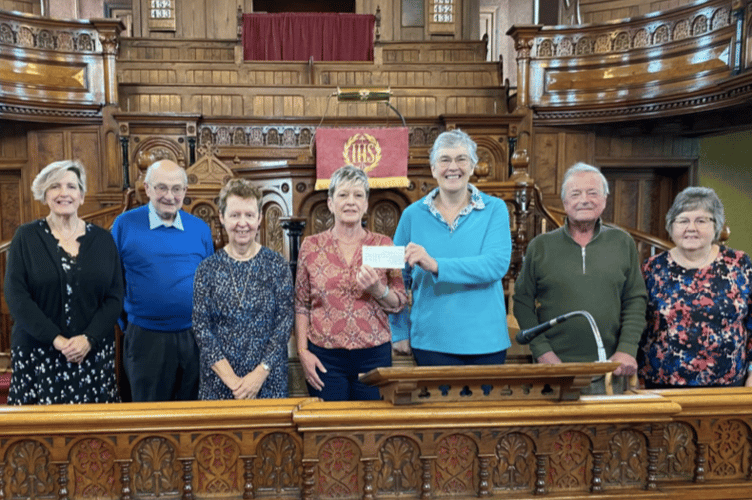 Lisa Marsh of Brecon and District Dial-a-Ride receives a £1,100 cheque from Ruth Stephens, Chair of the Plough Flower Festival Committee, alongside other committee members at the Plough Chapel