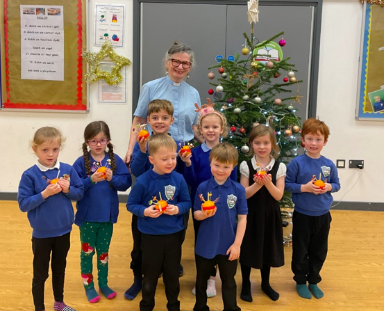 Rev Gill Jackson leads pupils in making Christingles during festive activities at Hay-on-Wye CP School