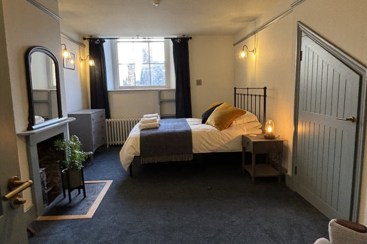 Blue bedroom with quirky door, made to fit between original beams
