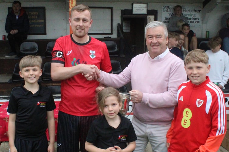 Frazer McAnally receives the League Cup from sponsor Pip Samuel