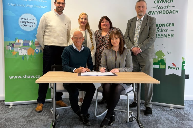 Russell Brown, Shaw Healthcare chief executive, and Nina Davies, Powys County Council director of social services and wellbeing, sign the new 15-year contract. They are joined by (back row, left to right): Geraint Evans, Rachel Evans, Sharon Frewin and Peter Lathbury