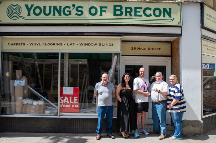Iain and Dawn McIntosh are pictured handing over the keys to Tom Griffiths, alongside his partner Hannah and father Gerwyn, who will both be helping to run the shop