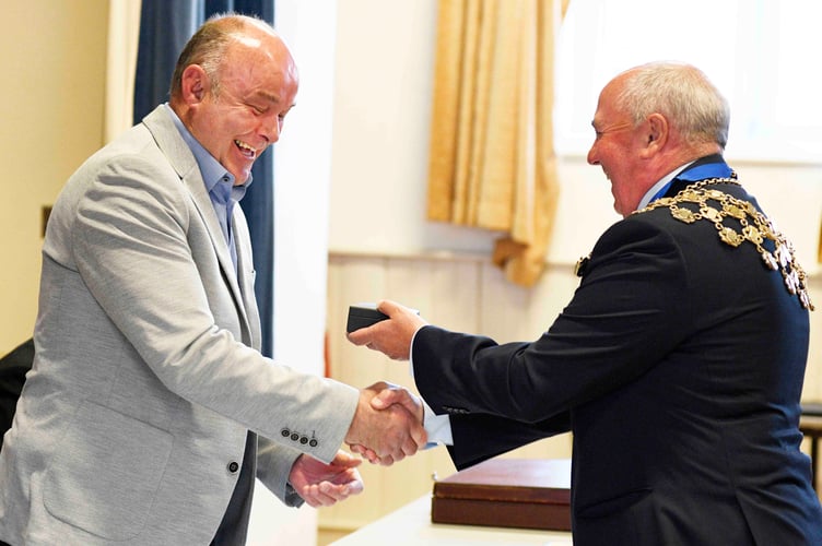 Handel Davies (right) presents outgoing Mayor Huw Thomas with the Mayor’s Medallion for services to the community