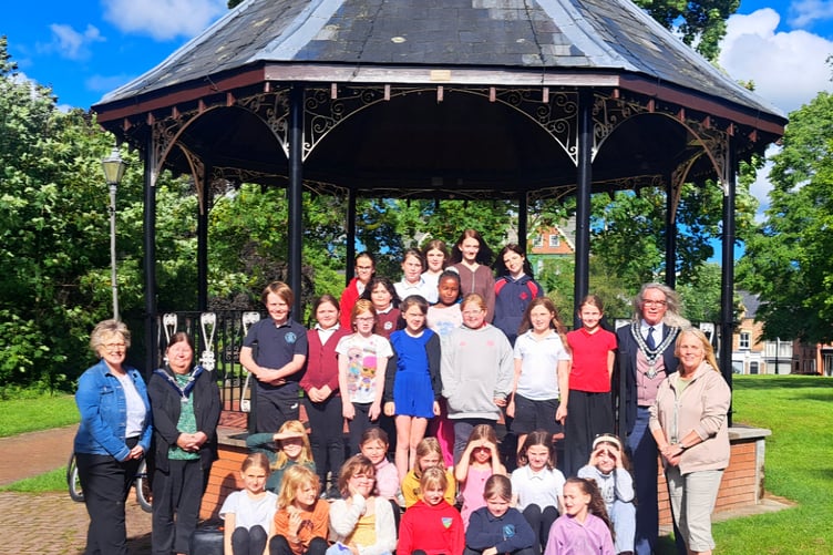 Children from the newly formed Llandrindod Wells community choir perform at the town bandstand, joined by Mayor Cllr Steve Deeks de Silva and Deputy Mayor Cllr Kim Nichols