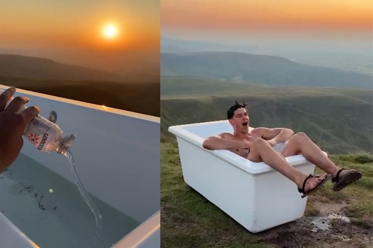 Content creator Tom Christopher takes a soak on Pen y Fan after carrying the bath tub to the summit