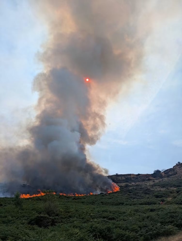 Flames and thick smoke engulf Hanter Hill during the days-long wildfire